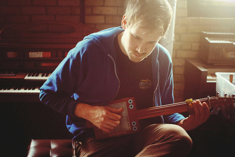 Musican Playing A Cigar Box Guitar